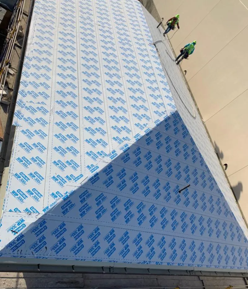 Professional roofers installing underlayment on a metal roof in Candler-McAfee